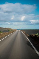 Back of female biking on Lanzarote paved road
