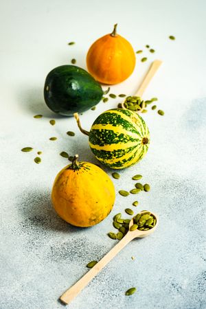 Colorful mini squash on counter with spoons of seeds