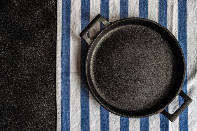 Empty pan on striped napkin as a table setting concept