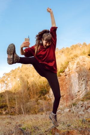 Young woman with smartphone dancing