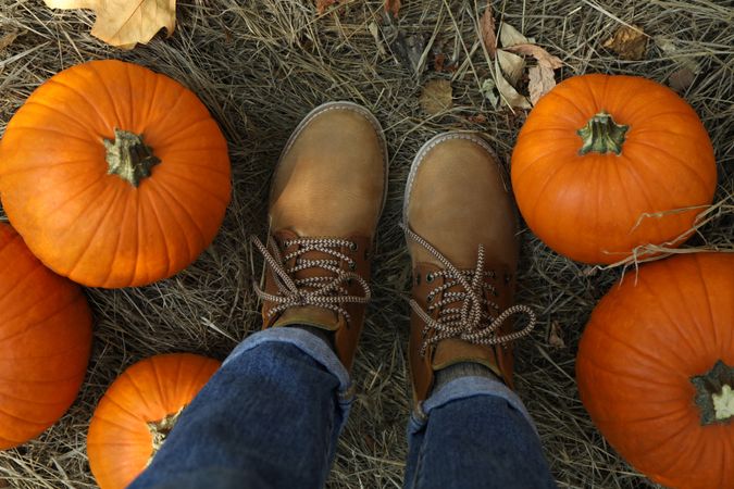 Autumn concept with pumpkins and woman in jeans and boots