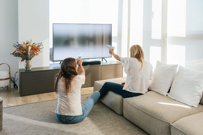 Anonymous women playing videogame with light guns