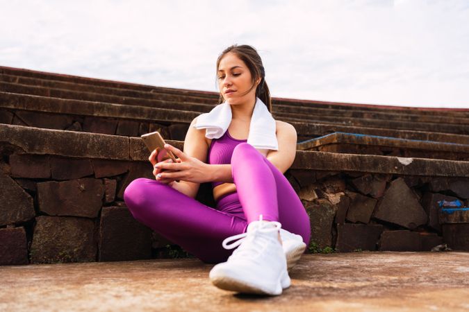 Slim woman in sportswear by stone stairs