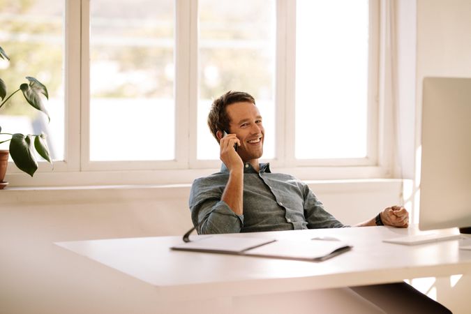 Relaxed businessman conversing over smart phone