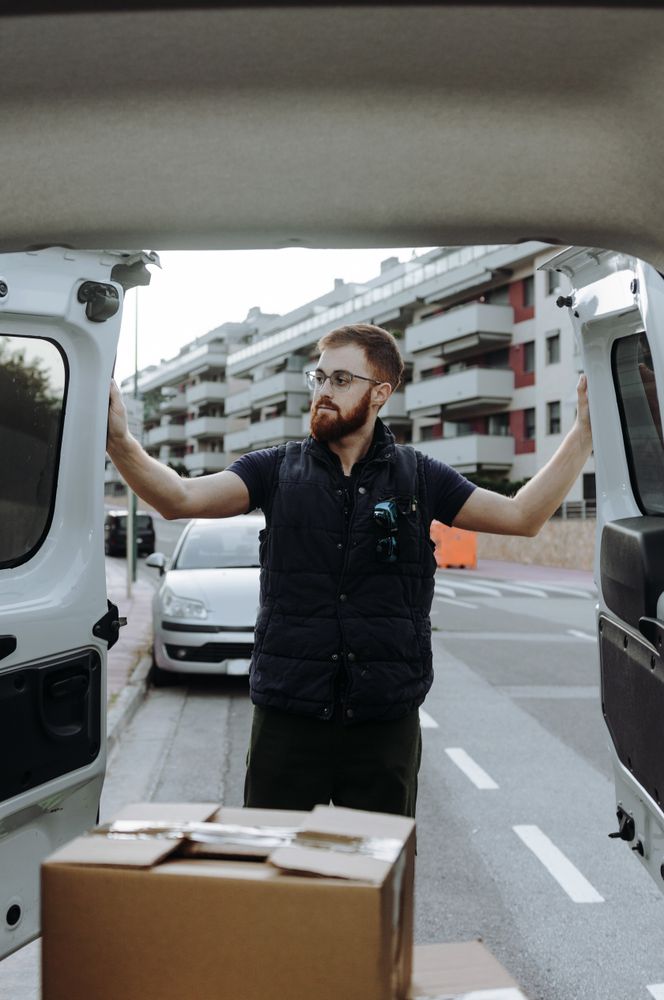 Courier taking out cartons of car for delivery completion
