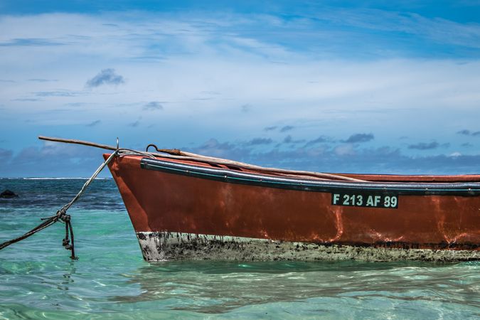 Side of red boat in clear tropical waters