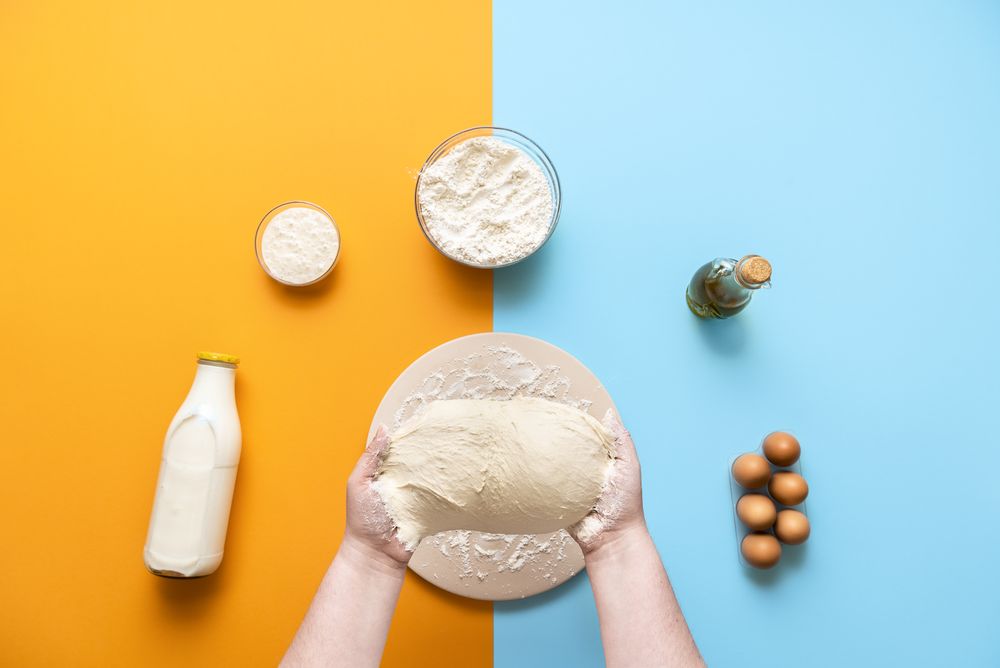 Kneading wet sticky dough on colorful background