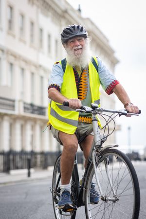 Bearded mature man riding bike through town