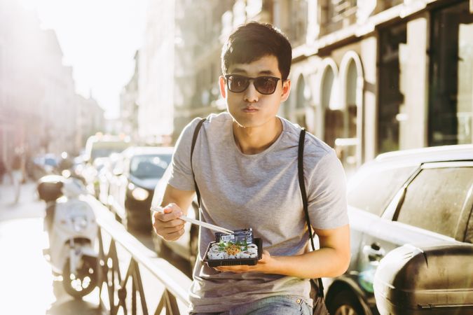 Man eating takeaway food on city street