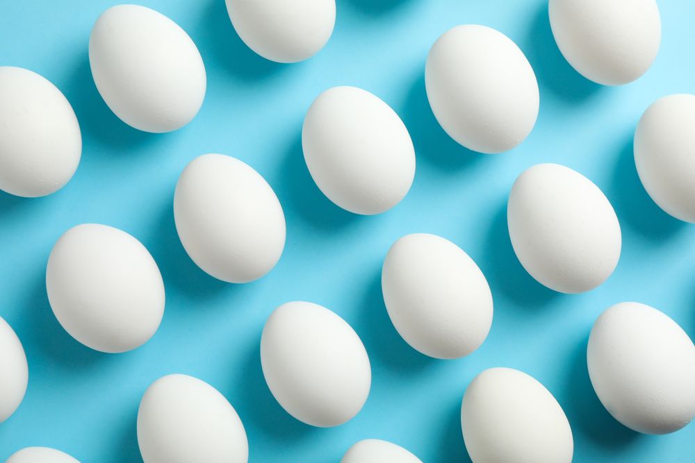 Flat lay composition with chicken eggs on color background, space for text