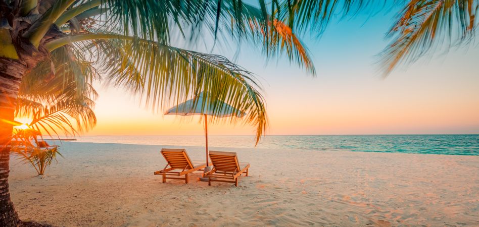 Two reclining chairs under parasols