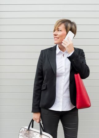 Businesswoman in chic suit speaking on cell phone