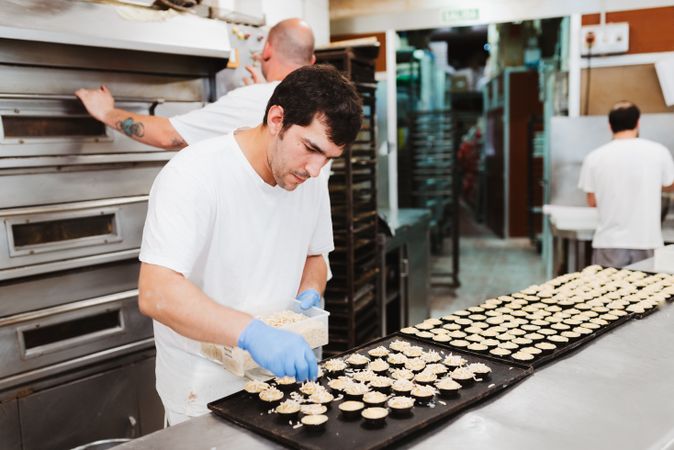 Confectioner decorating patisserie in bakery