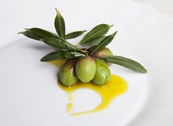 Green olives and leaves on plate