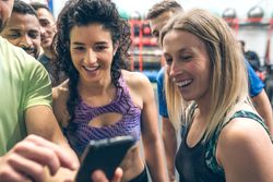Athletes looking at the mobile of a gym mate