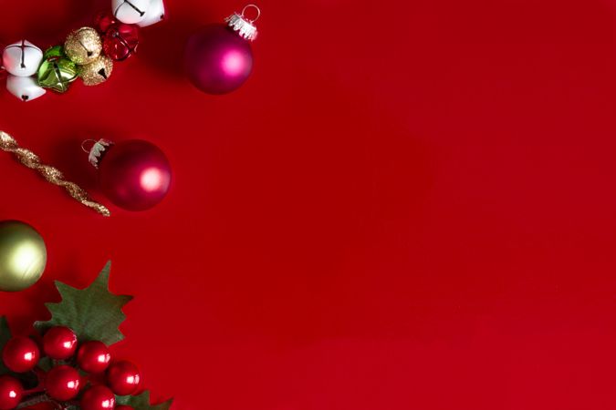 Red Christmas background with Christmas decorations, holly and ornaments.