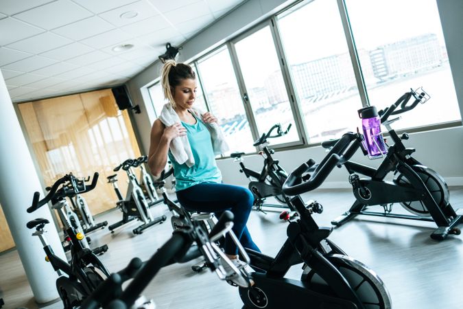 Woman with towel and water on exercise machine