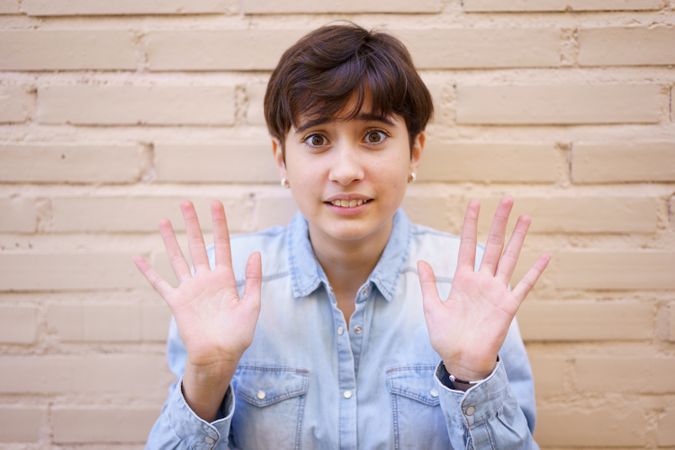 A Young Woman Displaying a Sense of Openness and Inviting Communication with Raised Hands