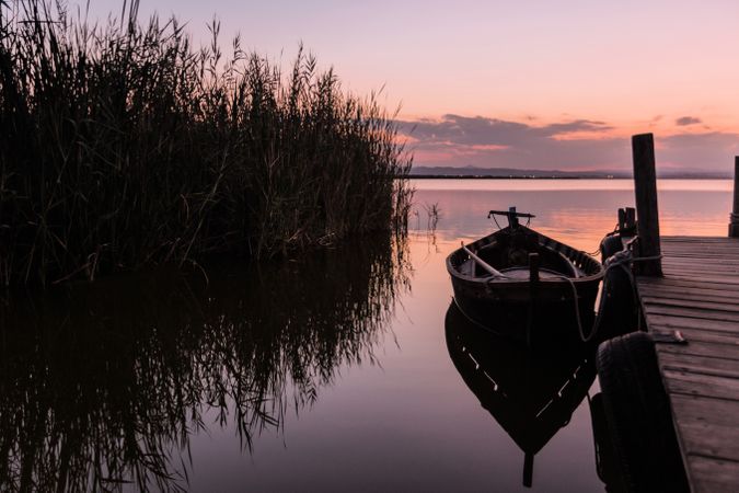 Moored boat by wooden pier