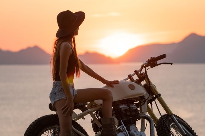 Woman with motorbike near sea