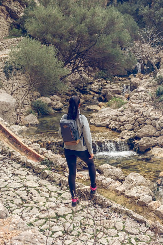 Woman admiring streaming creek in mountains
