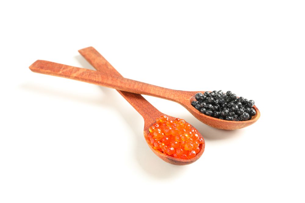 Spoons with caviar isolated on plain background