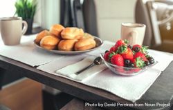 Breakfast pastries, coffee and bowl of berries in camper van, close up 0y3VR4