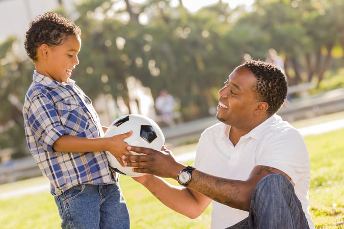Father Hands New Soccer Ball to Son