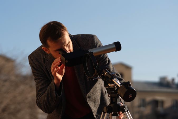 Astronomer adjusts specialized telescope on city rooftop to study sun