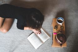 Female relaxing with a book and cannabis products