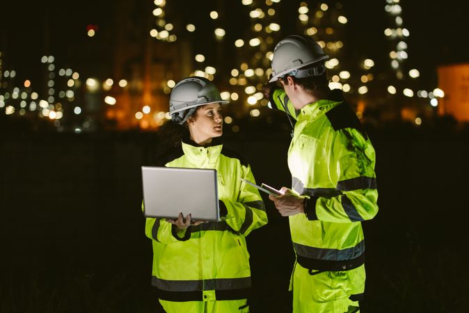 Engineer worker watching work monitor on tablet and checking at refinery factory