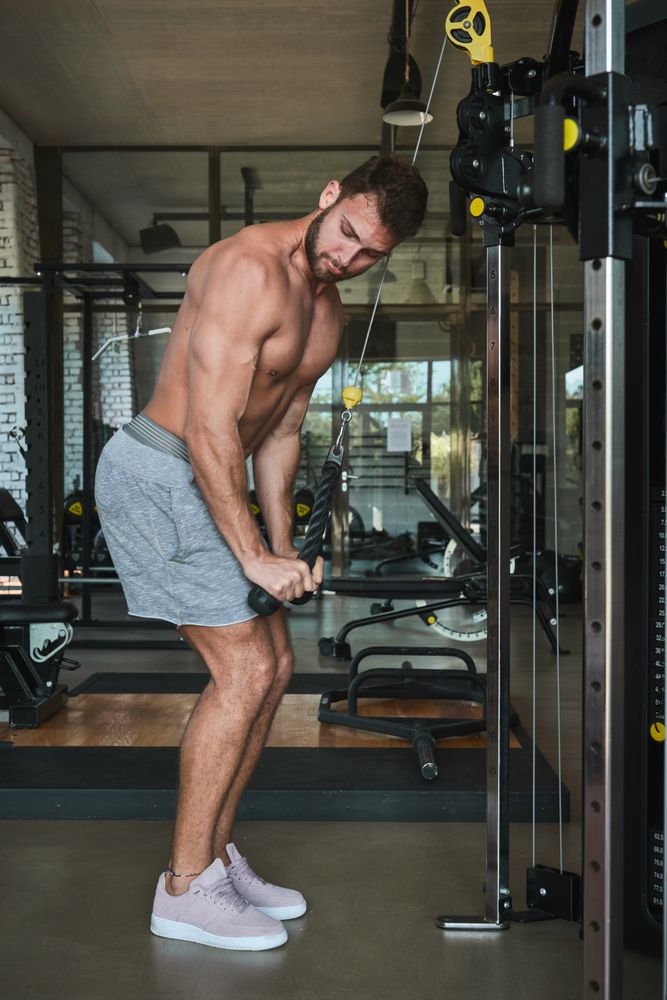 Guy using exercise machine in gym