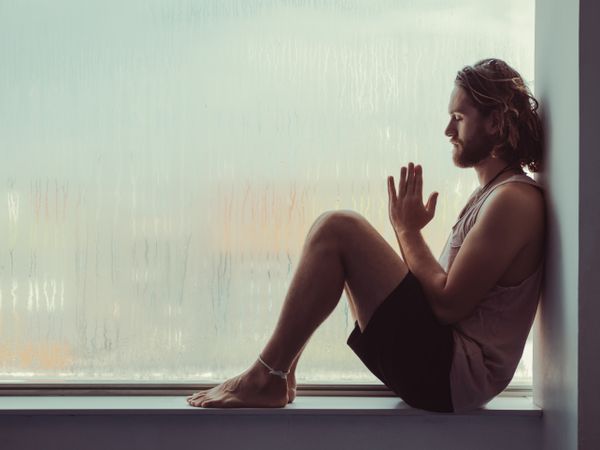 Man in mindfulness on window sill
