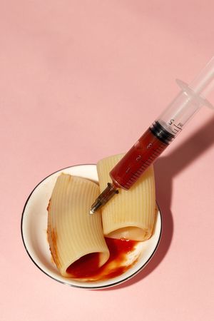 Stuffed pasta with red sauce in syringe