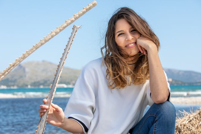 Young woman sitting near dried plants