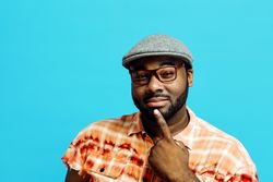 Man with finger on chin, thinking, looking at camera