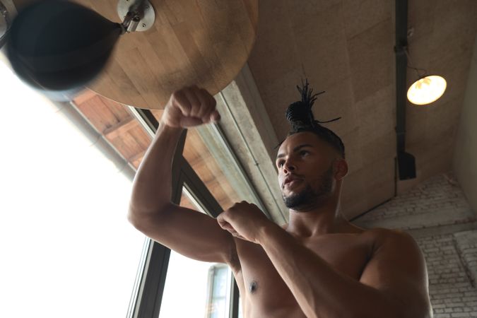 Black guy boxing in gym