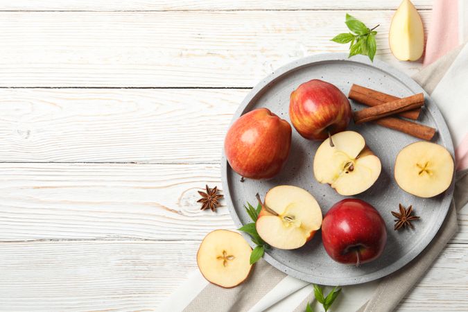Looking down at plate of apples, anise and cinnamon sticks, with copy space