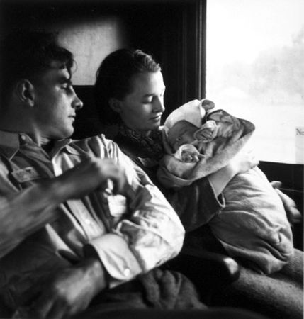 Young couple with baby in railroad passenger car during journey from Minnesota to San Francisco
