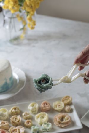 Hand holding buttercream flower
