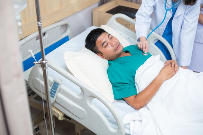 Physician visiting sick man in hospital bed