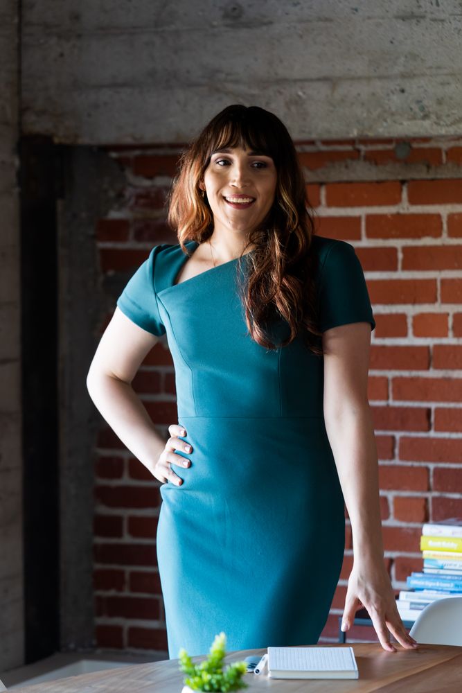 Transgender woman with hand on hip leading a meeting