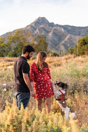 Happy active couple playing with dog outdoors