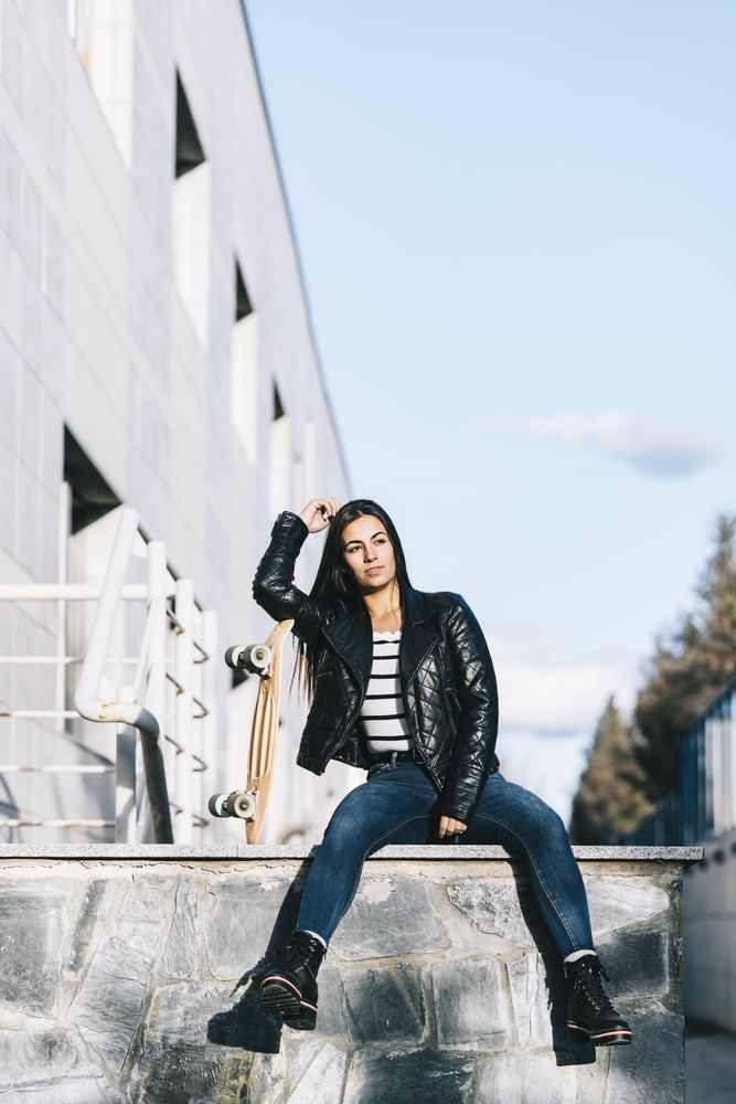 Young woman posing with skateboard