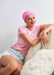 portrait of Woman sick with cancer with pink scarf sitting relaxed optimistic positive
