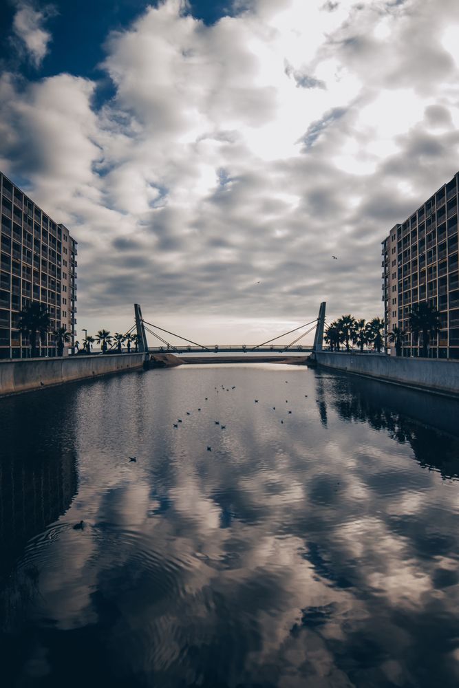 Watercanal between building and cloudy sky