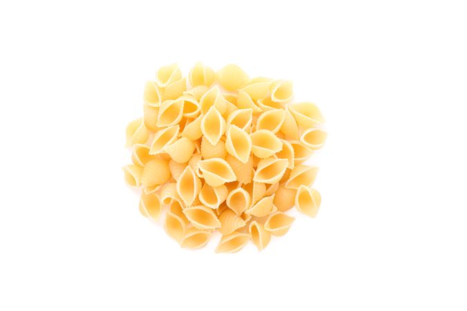 Pasta isolated on bright background, top view. Traditional shape of dry uncooked whole pasta