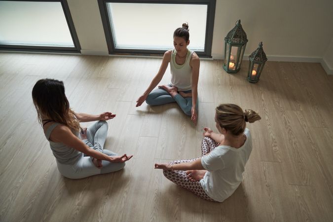 Group of females doing Padmasana exercise in spacious room
