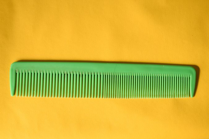 Green hair comb in yellow studio