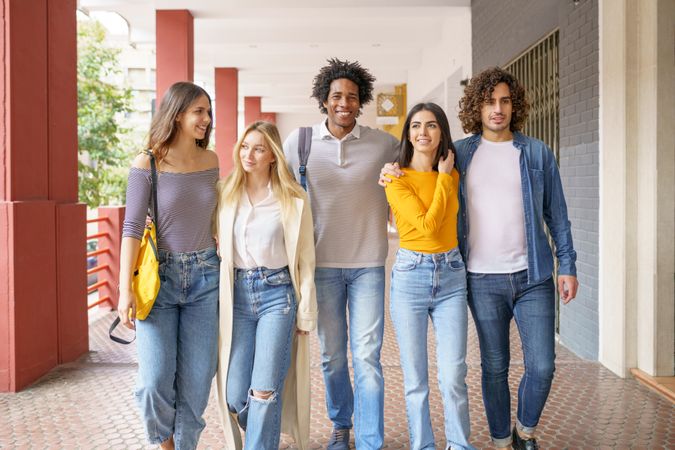 Chatty group of friends walking down street outside